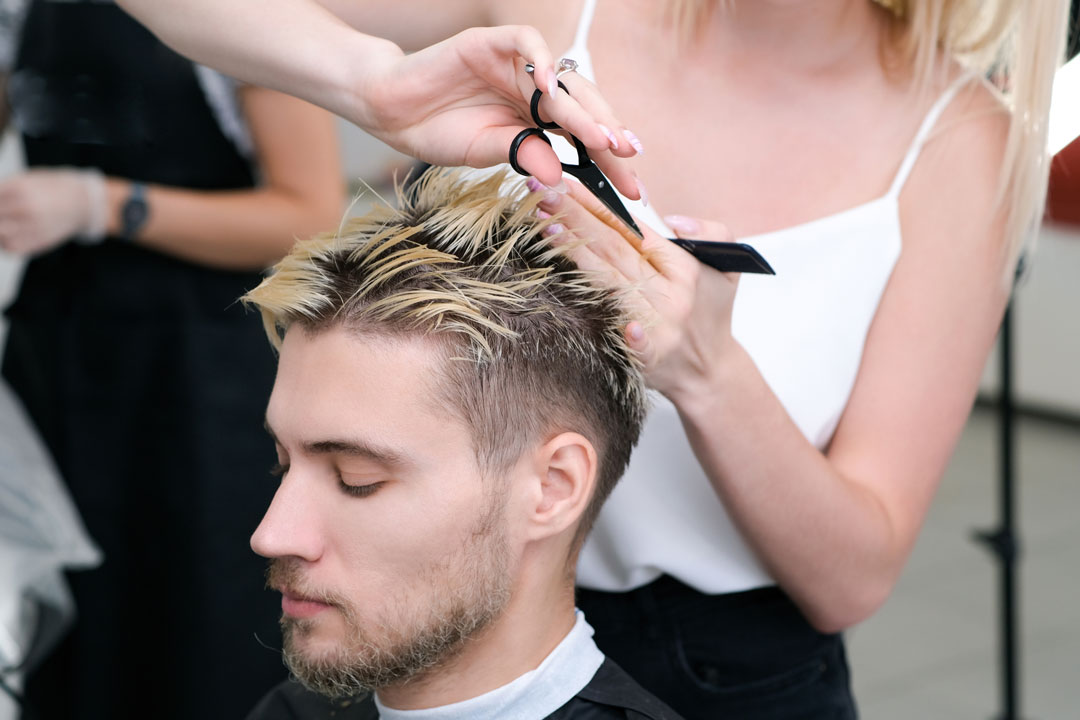 A man getting his haircut from professionals like Lemon Tree Hair Salons.