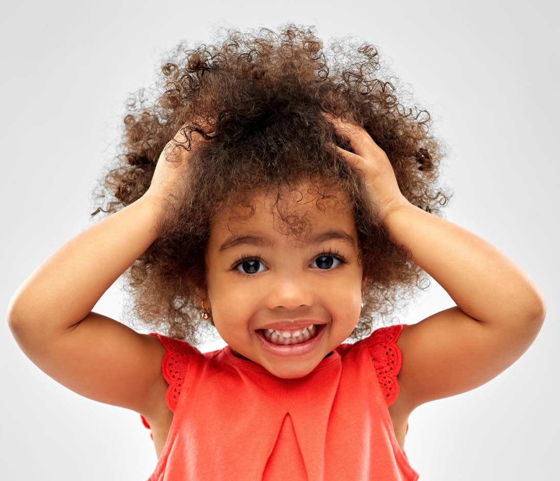 Cute little girl with beautiful curls at Lemon Tree Hair Salons.