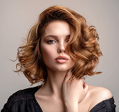 A woman with beautifully colored red hair from Lemon Tree Hair Salons.