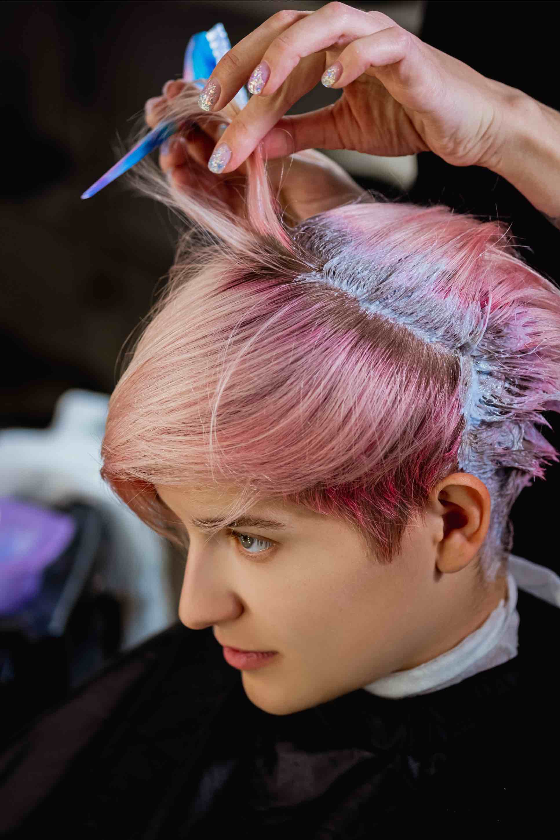 This woman with a pink pixie cut enjoys a low-maintenance cut with Lemon Tree Hair Salons.